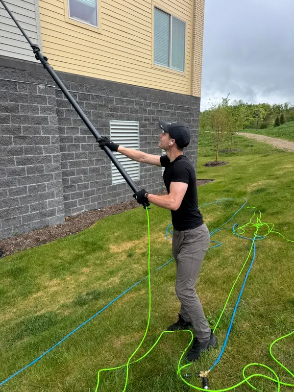 Water-fed pole cleaning on the side of an apartment building