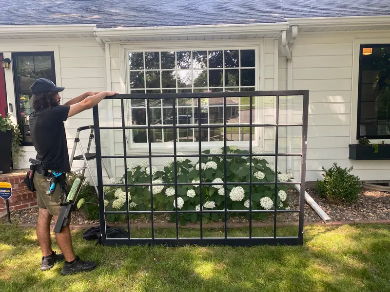 Technician cleaning a window frame on the lawn