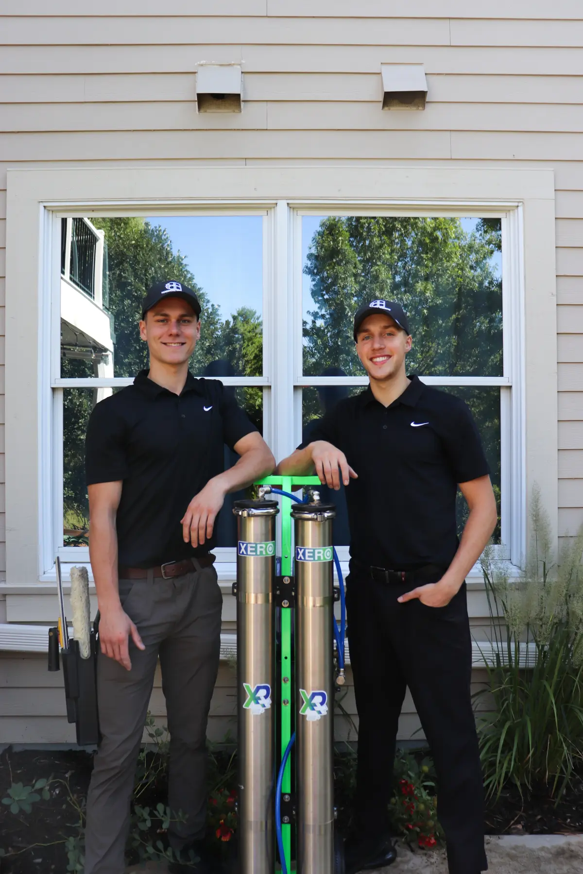 Sam and John, the owners of Peregrine Window Cleaning, with their water-fed poles