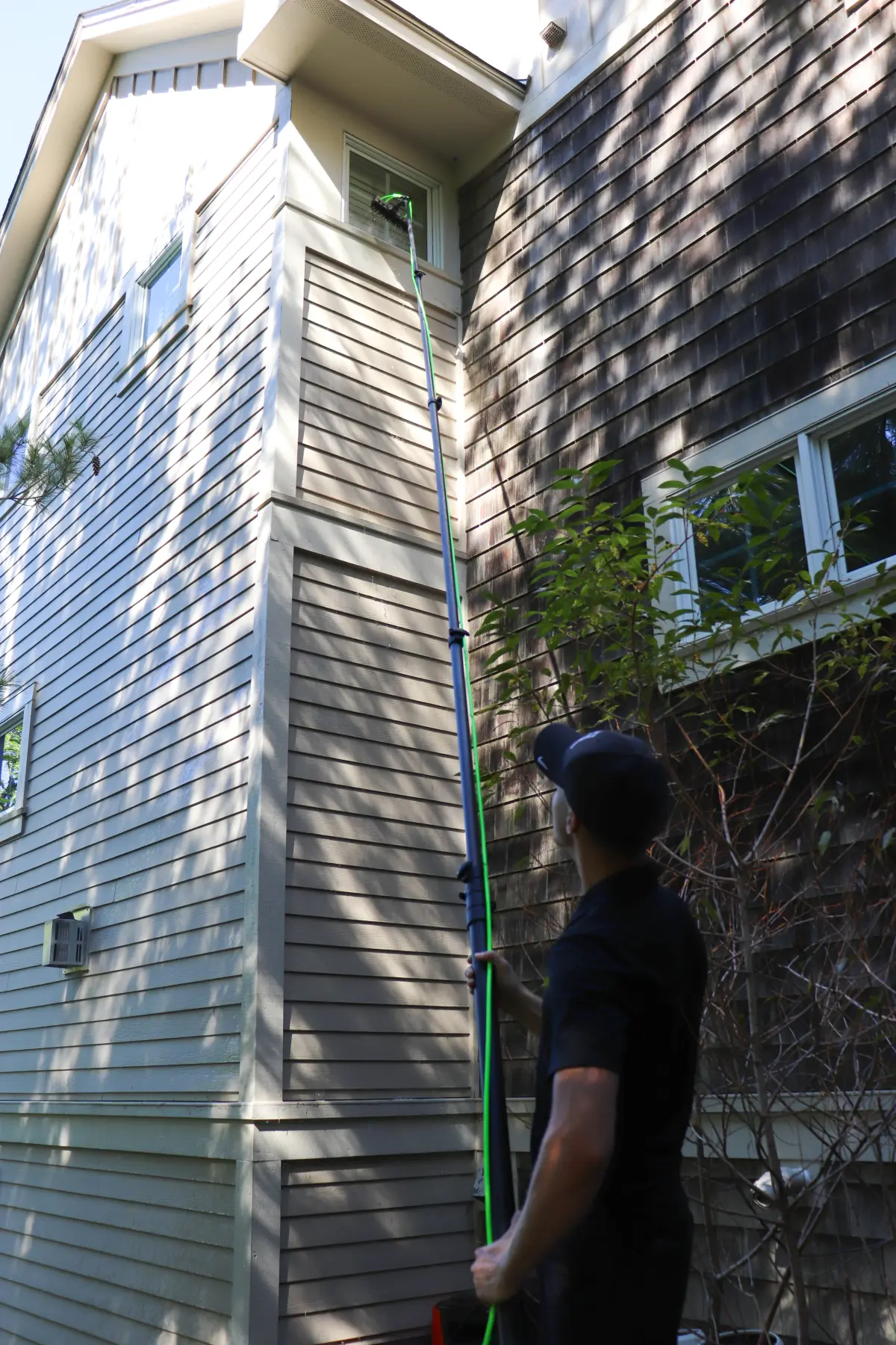 A Peregrine cleaner pressure washing a building exterior